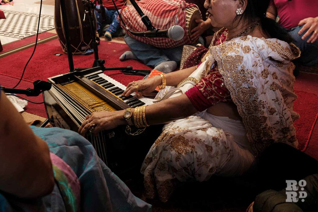 Woman playing the Indian harmonium, Holi Day festival, or Dolyatra, Hindu Pragati Sangha in Mile End, East London.