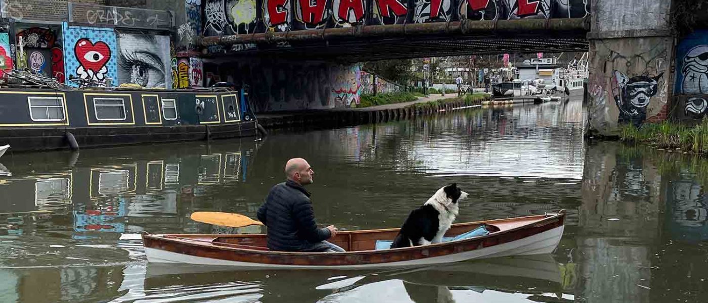 Dog adnd man on a kayak, cruising into Hackney Wick, East London