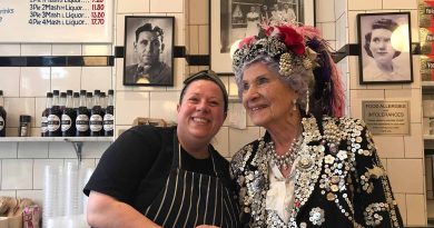 Phyllis Broadbent, the Pearly Queen of Islington, garbed in a mother-of-pearl outfit and a pink feather hat, with Leanne Black behind the counter at G Kelly's pie and mash shop on Roman Road