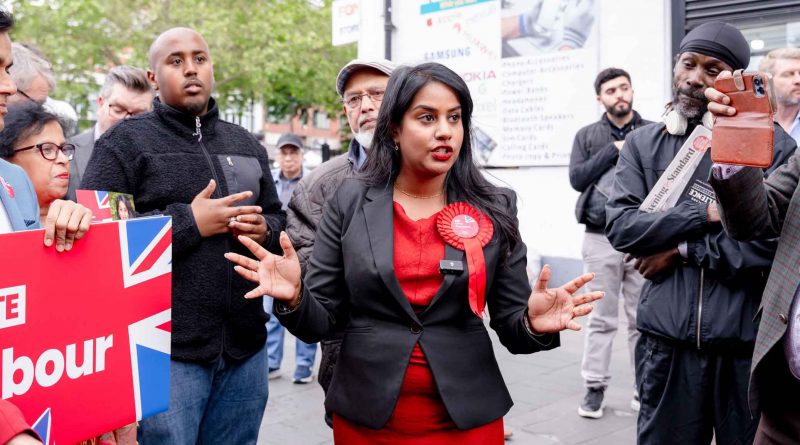 Uma Kumaran, Labour Party candidate for Stratford and Bow in Tower Hamlets and Newham, in a 'Labour' red dress with matching red rosette, talking to by standers on the streets.