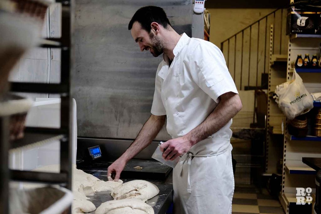 Miller preparing dough in bakery on Roman Road, East London.