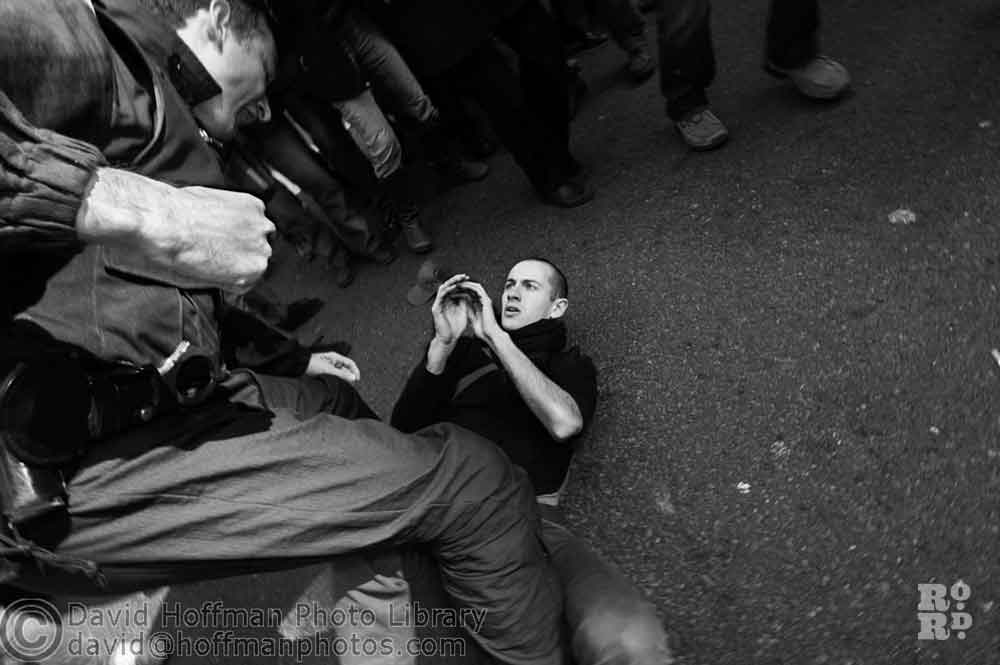 A black and white photo taken by David Hoffman of a police officer pinning down a demonstrator.