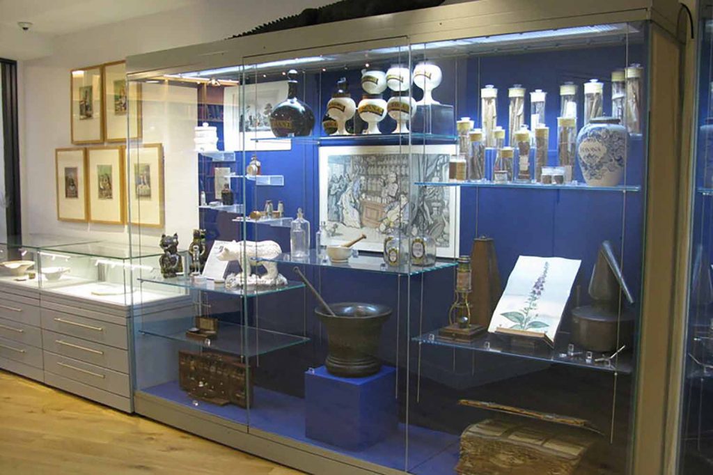 A selection of historical pharmaceutical equipment including an old, thick book, a plant drawing, and many mixing bowls and containers, Royal Pharmaceutical Society Museum,